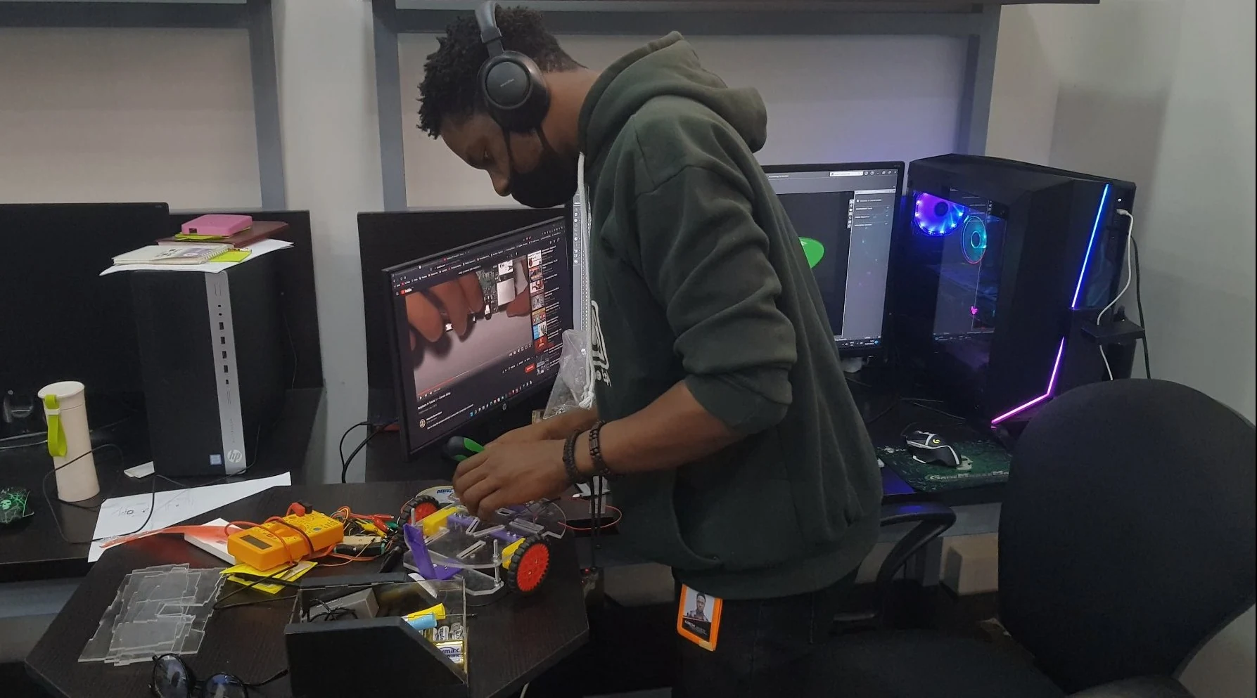 Timothy working on a wheeled robot prototype at an electronics bench